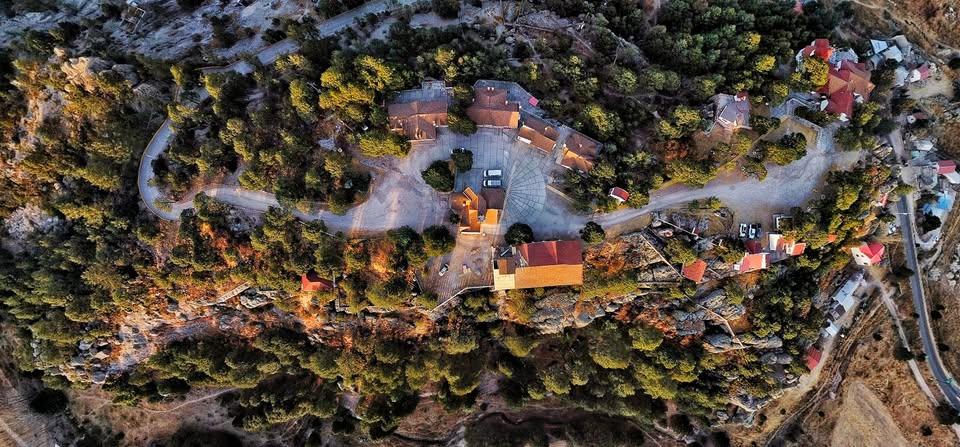 Cabaña iluminada entre pinos al atardecer en Sierra Bonita